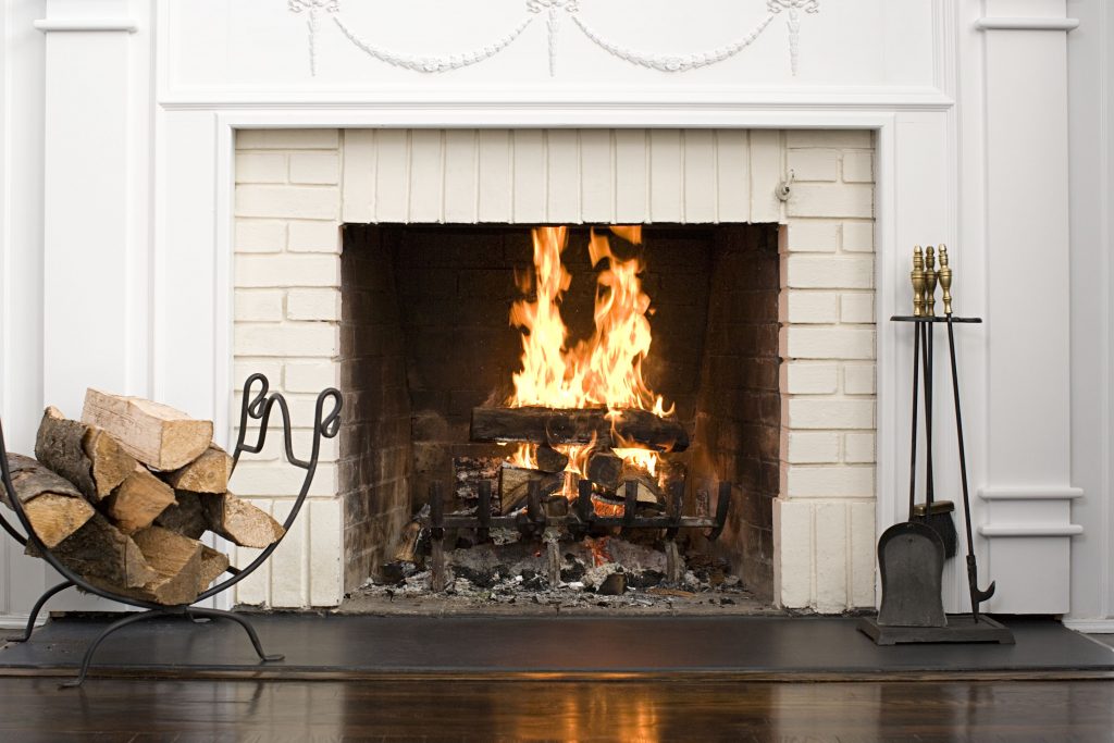 White fireplace with fire burning